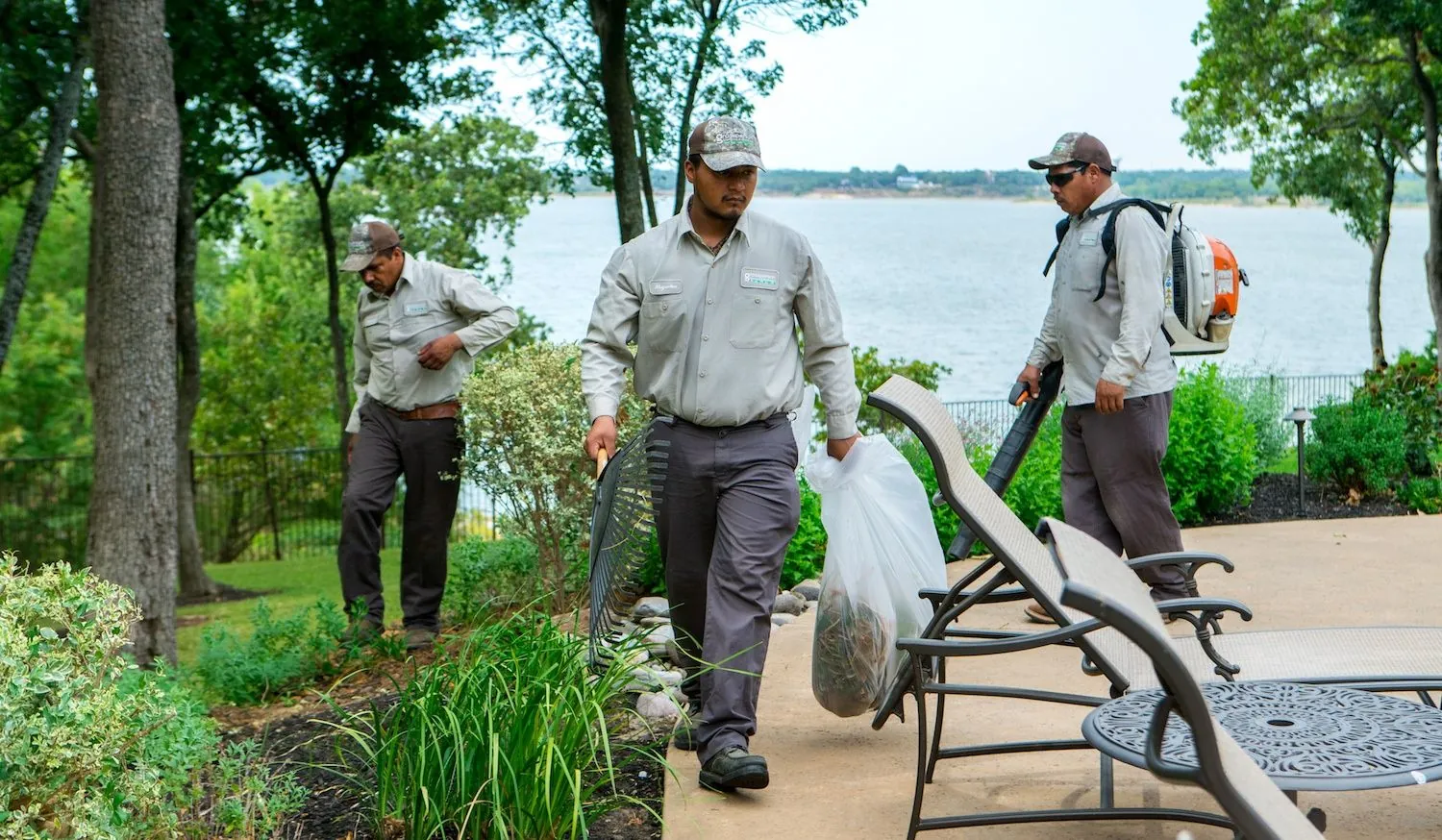 A landscaping crew maintaining a lakeside property
